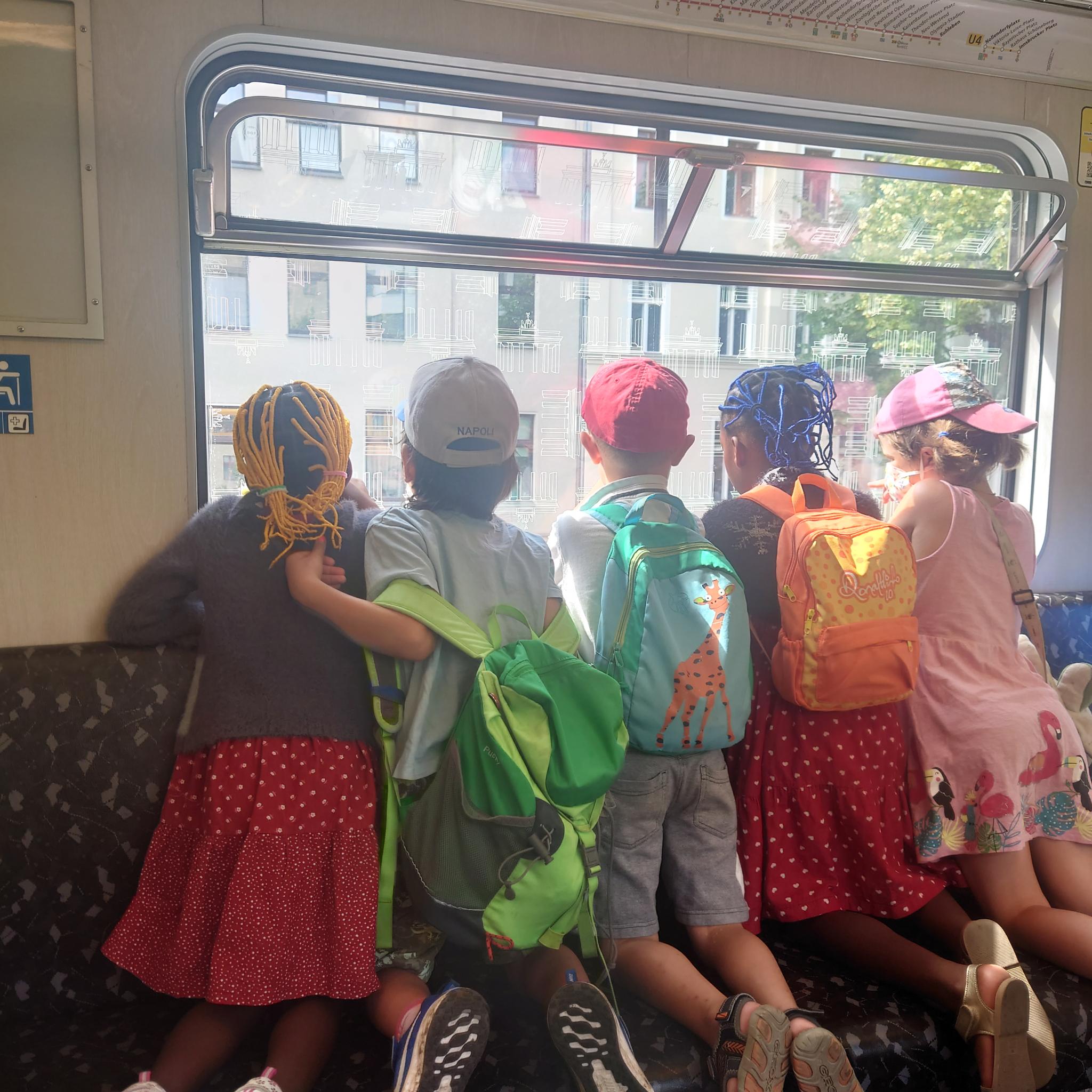 Kinder in der U-Bahn von hinten fotografiert